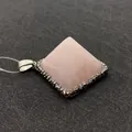 Macro view of pyramid-shaped pink quartz pendant with a shimmering crystal-set base - Rose Quartz