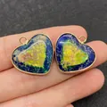 Pendentif cœur en pierre naturelle bleu et jaune avec serti doré présenté sur le doigt - Style 8