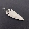 Détail d'un pendentif flèche en résine blanc laiteux avec calotte sertie de strass - Motif Tacheté Beige