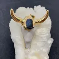 Macro shot of boho bull skull pendant with gold horns and blue stone inlay detail - Deep Blue Druzy Style (No. 4)