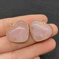 Pendentif cœur en quartz rose avec bordure dorée présenté en main pour la taille - Style 15