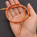 Handheld view of orange-red cylindrical emperor stone beads with natural texture for DIY - 5x13mm (ai-30 Pcs/Strand) / Orange Red