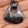 Gepolijste hartvormige hematiet hanger met zwart leren koord op een hand - 30x30mm / Hematiet