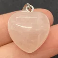 Herzförmiger Anhänger aus Rosenquarz mit Silberverschluss zwischen den Fingern - 20mm / Rosenquarz