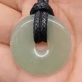 Pale green natural stone donut pendant with black cord on person's hand - Light Green Stone (No.20)