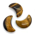 Three crescent moon shaped tiger eye stones showing natural mineral textures on white background - Tiger's Eye / 20x30mm (1 Piece)