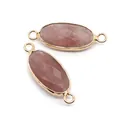 Macro view of faceted oval gold-plated strawberry quartz connectors for jewelry making - 11x30mm / Strawberry Quartz