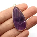 Purple crystal teardrop pendant with gold-plated edges held in fingers for scale - Purple Crystal