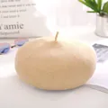 Minimalist beige wool beret for women with a cute top stem in a warm lifestyle setting - One Size / Beige
