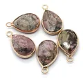 Macro shot of 5 natural teardrop stones with gold plated edges for DIY jewelry - Rhodonite with Black Lines