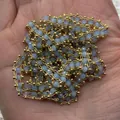 Chaîne de perles en cristal bleu clair facetté avec maillons dorés dans la main - Bleu Pâle