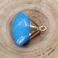 Sky blue fan-shaped stone pendant with gold-plated bail on natural wood background - Size 18