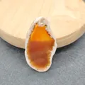 Macro-opname van onregelmatige agaat geode hanger met kristallen randen en boorgat - Oranje