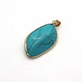 Detailed macro view of leaf-shaped turquoise pendant with gold plated metal border - Gold Edged (No. 1) / 22x40mm