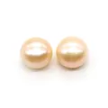 Detailed macro view of two round natural freshwater pearls with warm cream pink luster - 2-2.5mm / Pink