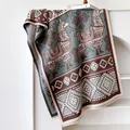 Nahaufnahme von Ethno-Alpaka-Muster auf dickem grau-braunem Jacquard-Strickschal - 185x65cm / Blau