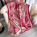 Sciarpa bicolore rosso e beige con motivi geometrici e frange su una sedia - Stile Lungo / Rosso