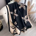 Close-up of floral cashmere feel shawl with fringe tassels on a beige vintage chair - Black
