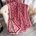 Dicker rot-beiger Bohème-Schal mit Blumenmuster und Fransen auf einem Sessel - 185cm / Rot
