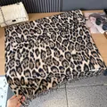 Nahaufnahme des Leopardenmusters mit Fransen und gewebtem Etikett auf einem Tisch - 200 / Gebrochenes Weiß