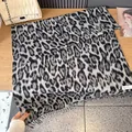 Grauer Schal mit Leopardenmuster, langen Fransen und Webeetikett auf Holztisch - 200 / Schwarz