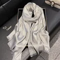 Detail of silver-grey silk scarf featuring shimmering metallic glitter and fringe edges - Gray