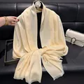 Elegant beige silk-like scarf with heart jacquard pattern and fringe tassels on a sofa - Tsm-151 Beige