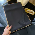 Black tencel cotton scarf with silver glitter threads and tassels on a gold tray - Black