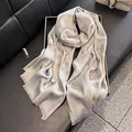 Elegante chal largo gris plateado con acabado de seda brillante y bordes de flecos - Gris
