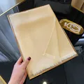 Elegant champagne gold silk scarf with shimmering metallic finish and fringe details - Apricot