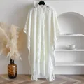 Detailed close-up of white knitted hollow-out cardigan shawl with decorative long tassels - White