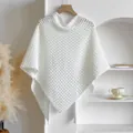 Close-up of white crochet hollow-out poncho with diamond mesh and tassel hem - White