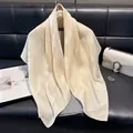 Elegant cream houndstooth jacquard silk scarf draped over a light grey sweater - 90x90cm / Apricot
