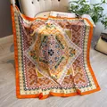 Silk square scarf with vintage orange mandala pattern on a beige decorative chair - Orange