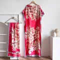 Detailed view of red floral silk kaftan dress with matching scarf on elegant hangers - Red Lily Print