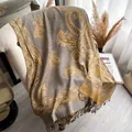 Sciarpa in cashmere con motivo paisley grigio e giallo e nappe su una poltrona - Cachi