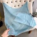 Light blue pleated silk scarf with white zigzag edges on a soft chair - Large Square / Blue