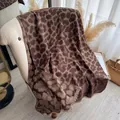 Thick leopard print cashmere shawl with golden thread and tassels on a beige chair - 185cmx65cm / Brown