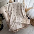Beige and gold heart jacquard scarf with fine fringe tassels on a soft fabric chair - White