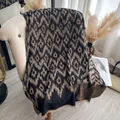 Ethnic geometric pattern shawl in black and champagne gold with fringe trim on sofa - 185x65 / Black