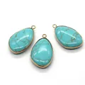 Druppelvormige turquoise hanger met natuurlijke textuur en een gouden metalen rand - Blauw Turkoois