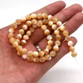 Handheld view of 6-8mm orange and white sea shell beads for DIY jewelry making - 2mm / Nude