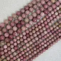 Macro view of natural round rhodonite stone beads with unique pink and grey textures - Red Wood Grain Stone