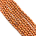 Close-up of orange imperial jasper round beads with natural white veins for DIY jewelry - Small Round Beads / Orange Texture