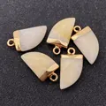 Detailed view of faceted natural stone horn pendants with gold-plated caps and loops - Milky White Stone