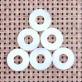 Λεπτομέρεια έξι μενταγιόν opal donut 20mm σε χαλάκι με υφαντή υφή και φυσικό φόντο - Οπάλιο