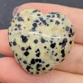 Polished heart-shaped Dalmatian Jasper stone with black spots held by hand - 30x30mm, 14mm Thickness / Dalmatian Jasper