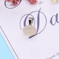 Macro detail of a hexagonal milky white natural stone pendant with a silver clasp - Agate