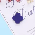 Deep blue four-leaf clover pendant with silver metal clasp on minimalist card background - Synthetic Blue Jade