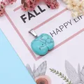 Detailed view of apple-shaped turquoise stone pendant with silver clasp on floral card - Blue Turquoise